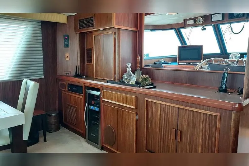 Slide: The Image of Interior of 1983 Hatteras 53 Extended Deckhouse Motor Yacht with wood cabinetry and dining area. - 49