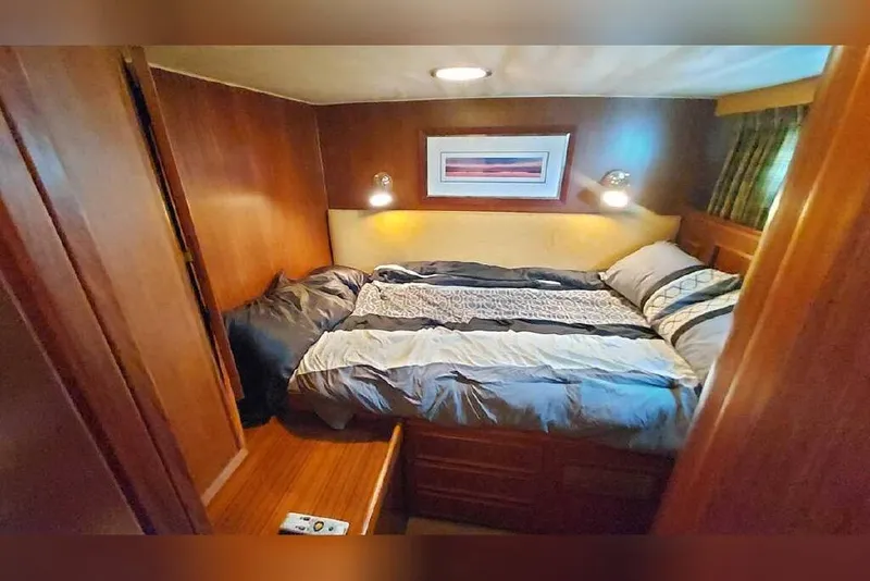 Slide: The Image of Cozy bedroom in 1983 Hatteras 53 Extended Deckhouse Motor Yacht with wood paneling and soft lighting. - 51