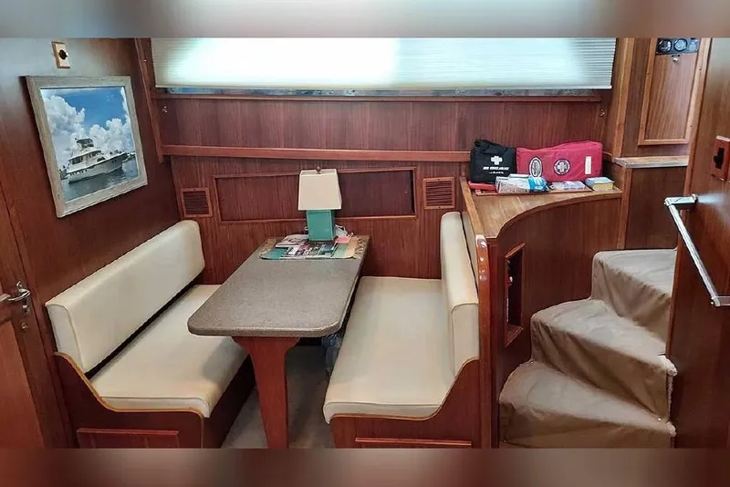 Slide: The Image of Interior of 1983 Hatteras 53 Motor Yacht with dining area and wooden decor. - 53