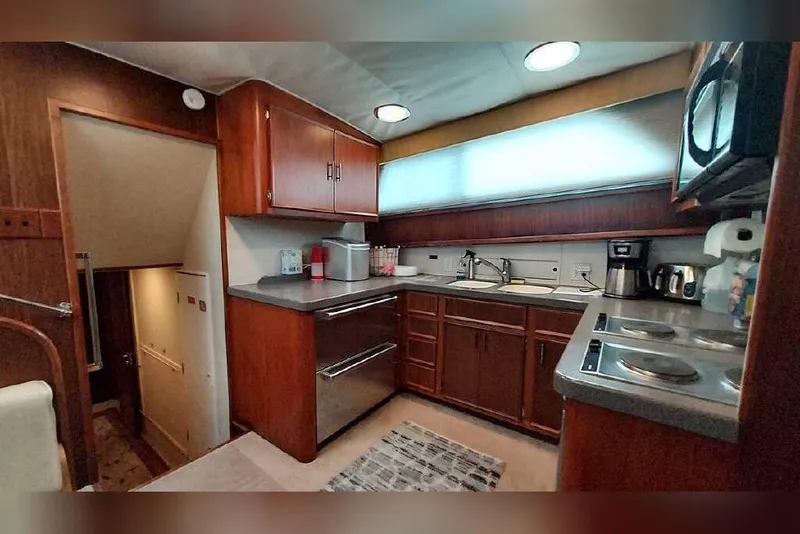 Slide: The Image of 1983 Hatteras 53 Motor Yacht kitchen with wood cabinets, appliances, and counter space. - 54