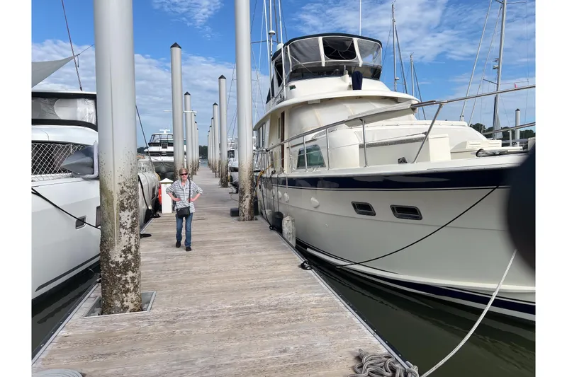 Slide: The Image of 1983 Hatteras 53 Extended Deckhouse Motor Yacht docked at marina under blue sky. - 60