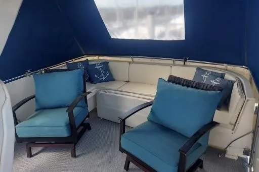 Slide: The Image of 1983 Hatteras 53 Extended Deckhouse Motor Yacht interior with blue seating and nautical decor. - 64
