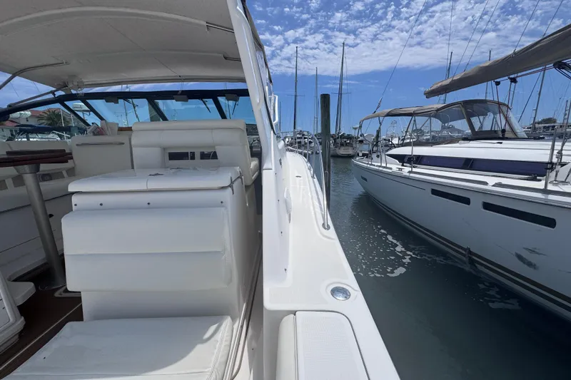 Slide: The Image of 2001 Tiara Yachts 3500 Open docked in a marina, showcasing sleek design and spacious seating. - 11