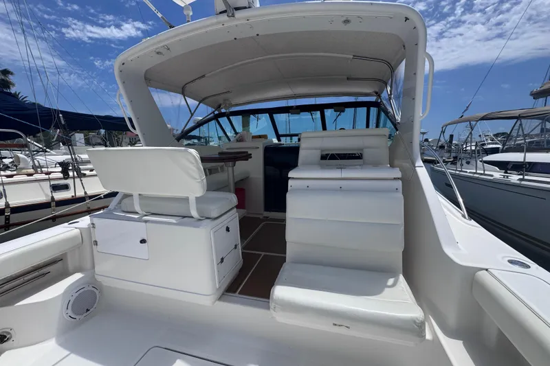 Slide: The Image of 2001 Tiara Yachts 3500 Open with white seating, docked under a clear blue sky. - 13