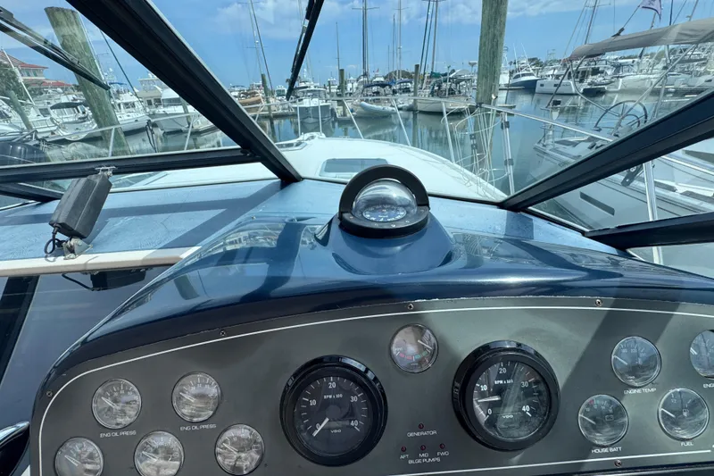 Slide: The Image of Cockpit view of 2001 Tiara Yachts 3500 Open, showcasing dashboard and marina. - 24