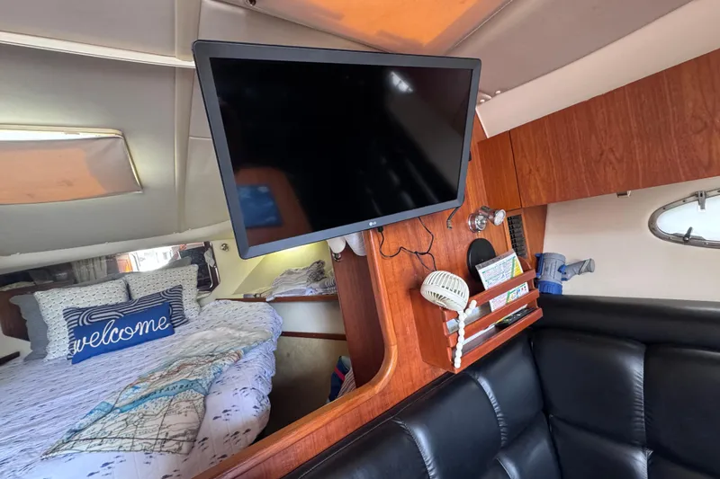 Slide: The Image of Interior of 2001 Tiara Yachts 3500 Open with TV, bed, and welcome pillow. - 53