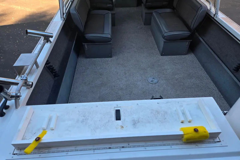 Slide: The Image of 2021 Alumaweld Intruder Outboard 20 interior with seating and fishing rod holders. - 10