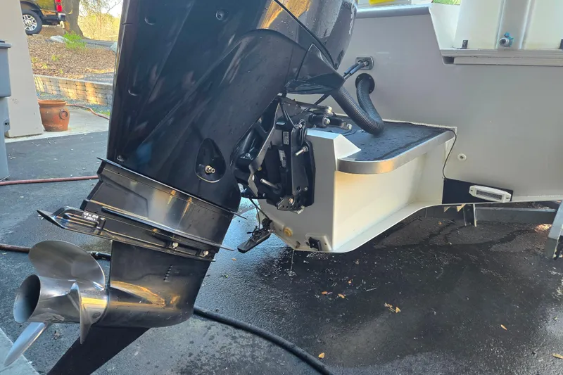 Slide: The Image of 2021 Alumaweld Intruder Outboard 20 motor and propeller on a wet driveway. - 23