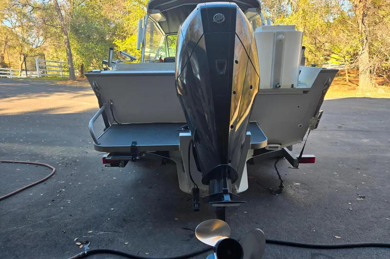 Slide: The Image of 2021 Alumaweld Intruder Outboard 20 boat with powerful engine, parked outdoors. - 4