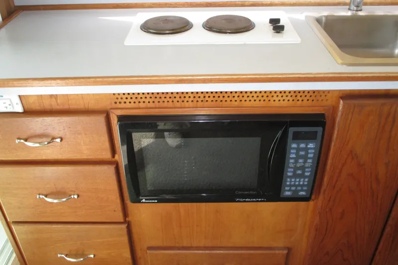 Slide: The Image of 1972 Uniflite 36 Sport Sedan kitchen with microwave, stove, and sink. - 16