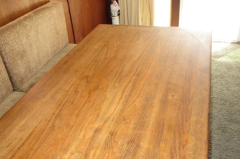 Slide: The Image of Wooden table and bench seating inside a 1972 Uniflite 36 Sport Sedan boat. - 22