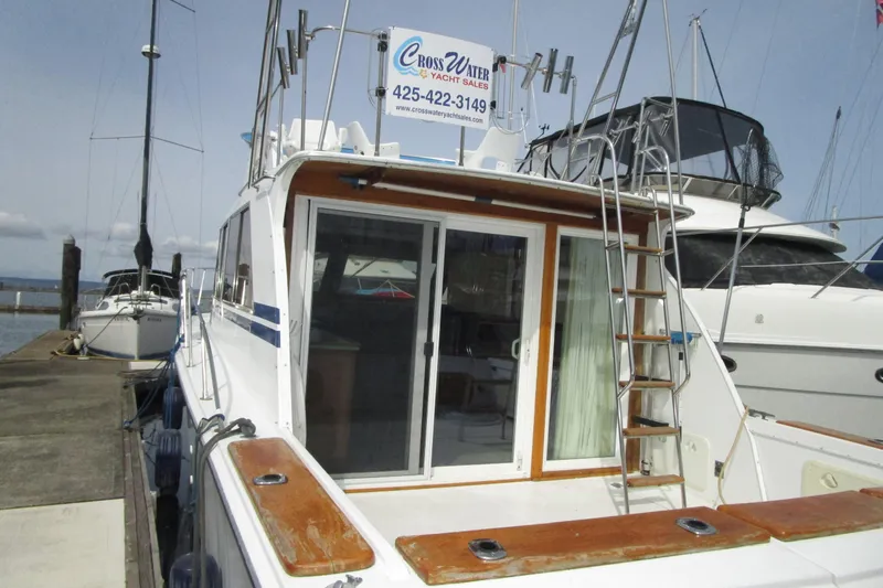 Slide: The Image of 1972 Uniflite 36 Sport Sedan docked, featuring rear deck and ladder. - 5