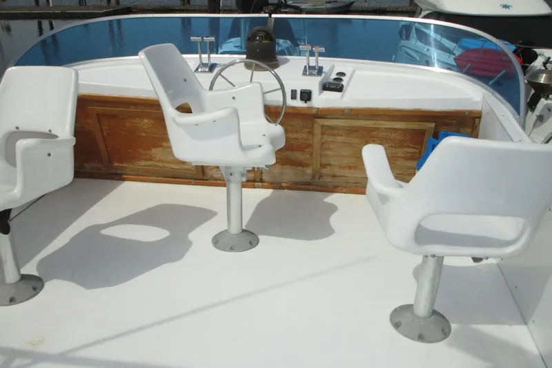 Slide: The Image of 1972 Uniflite 36 Sport Sedan boat cockpit with white chairs and wooden dashboard. - 7