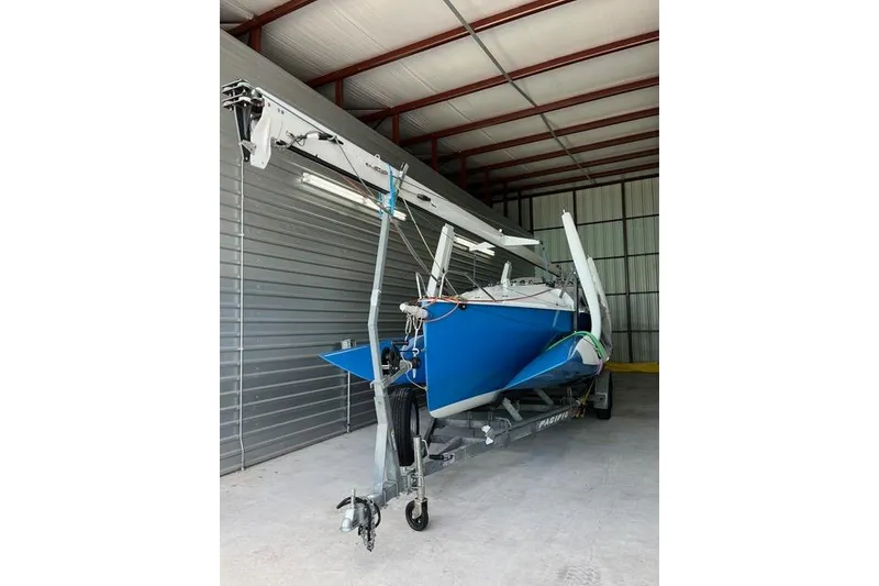 Slide: The Image of 1996 Farrier F-25C sailboat in storage, blue hull, on trailer. - 11