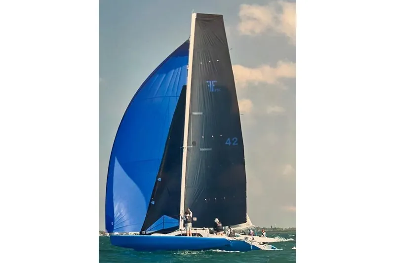 Slide: The Image of Sailing yacht Farrier F-25C, 1996 model, with blue and black sails on open water. - 5