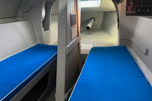 Slide: The Image of Interior of a 1996 Farrier F-25C sailboat with blue cushioned seating. - 8