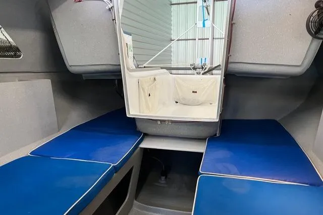 Slide: The Image of Interior of a 1996 Farrier F-25C sailboat with blue cushioned seating. - 9