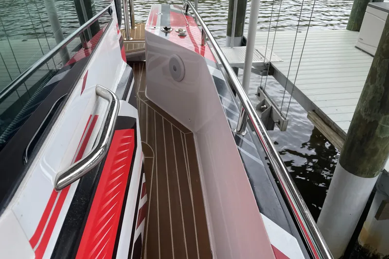 Slide: The Image of 2021 Axopar 28 Cabin boat with sleek design and vibrant red accents docked by the water. - 12