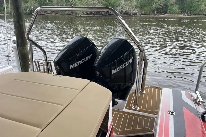 Slide: The Image of 2021 Axopar 28 Cabin with dual Mercury outboard engines on a calm river. - 13