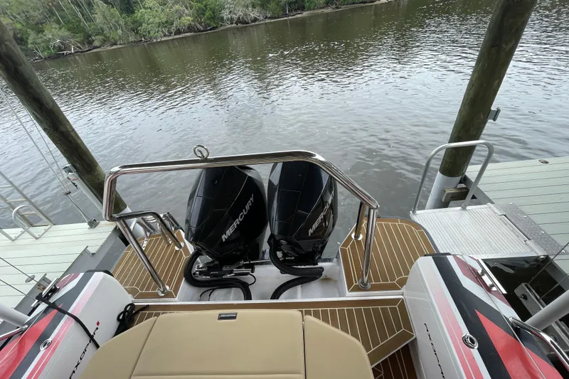 Slide: The Image of 2021 Axopar 28 Cabin boat with dual Mercury engines docked by a river. - 16