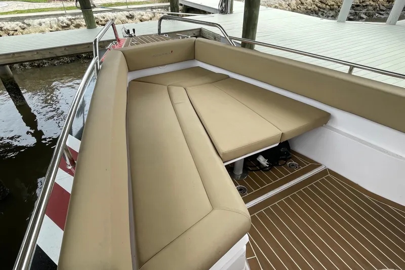Slide: The Image of 2021 Axopar 28 Cabin boat with tan seating and wooden deck. - 17