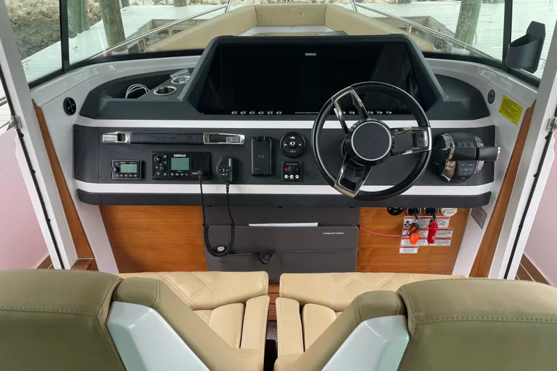 Slide: The Image of Interior view of 2021 Axopar 28 Cabin boat dashboard with steering wheel and controls. - 23