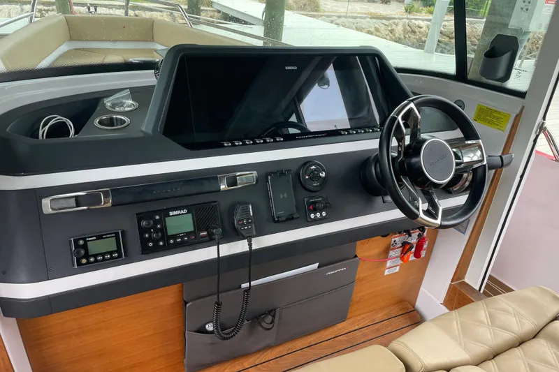 Slide: The Image of 2021 Axopar 28 Cabin helm with modern controls and steering wheel. - 24