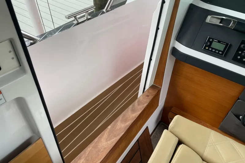 Slide: The Image of Interior view of 2021 Axopar 28 Cabin, featuring wood accents and control panel. - 26