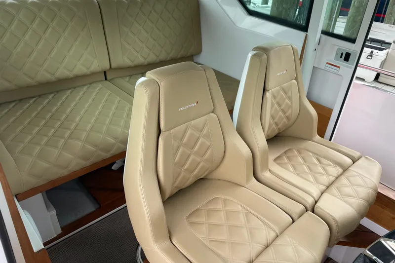 Slide: The Image of Luxurious interior of 2021 Axopar 28 Cabin with beige quilted seating. - 29