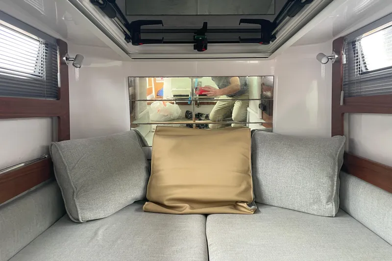 Slide: The Image of Interior of 2021 Axopar 28 Cabin with gray cushions and mirrored wall. - 31