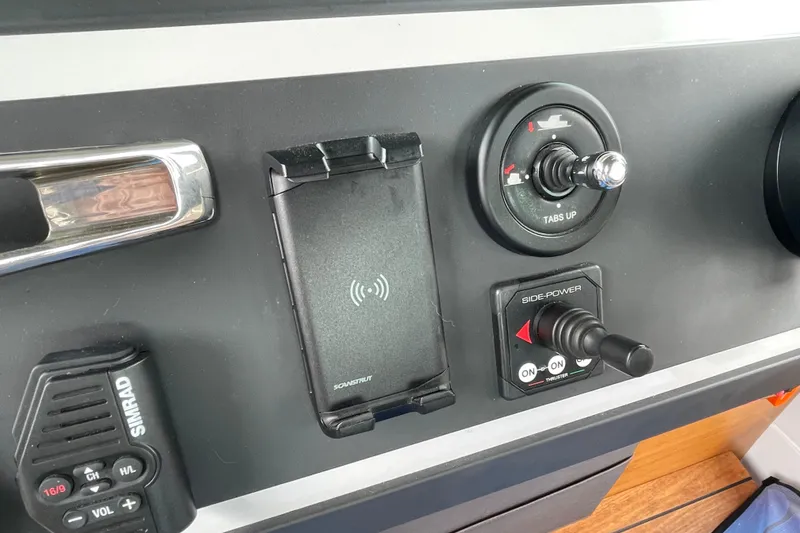 Slide: The Image of Control panel of a 2021 Axopar 28 Cabin boat with various switches and a phone holder. - 34