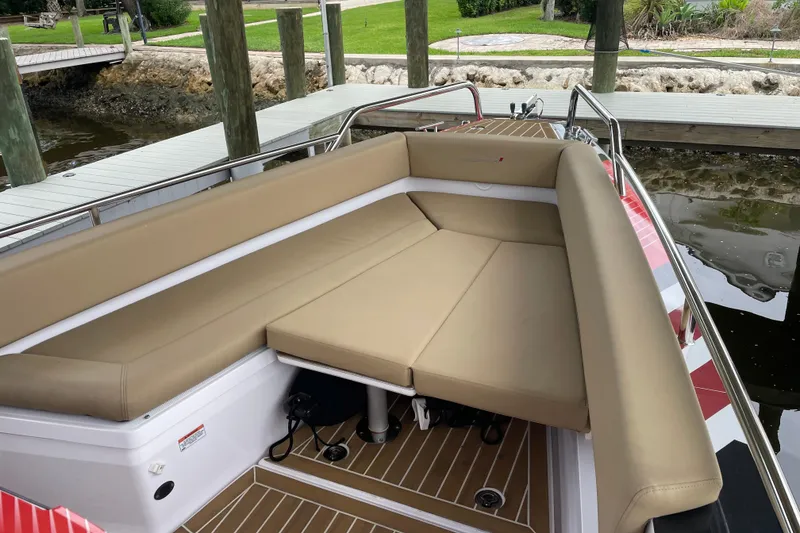 Slide: The Image of 2021 Axopar 28 Cabin boat with beige seating, docked by a wooden pier. - 38