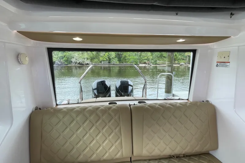 Slide: The Image of Interior view of 2021 Axopar 28 Cabin boat with rear window and water backdrop. - 40