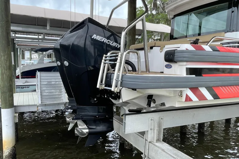 Slide: The Image of 2021 Axopar 28 Cabin with Mercury outboard motor on a boat lift. - 6