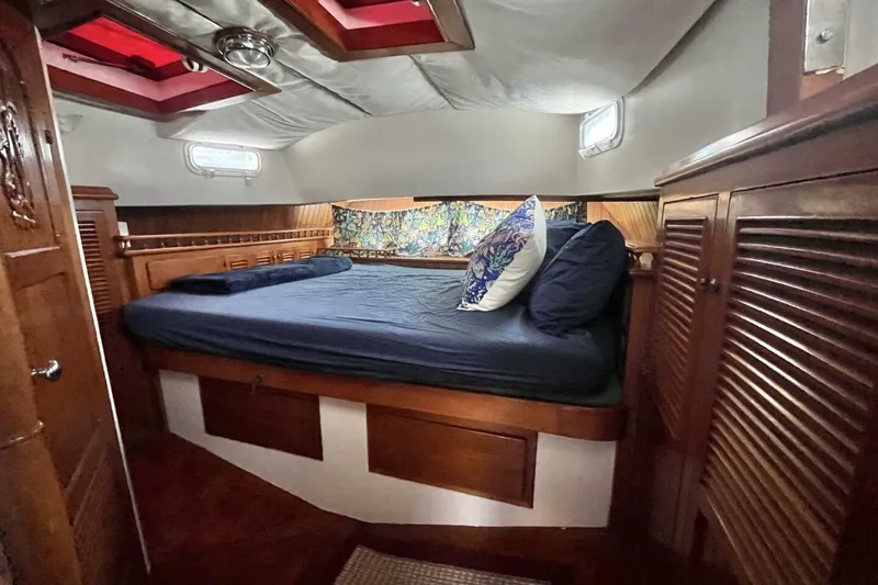 Slide: The Image of Cozy cabin interior of a 1979 Hardin 44 sailboat with wooden furnishings and a comfortable bed. - 7