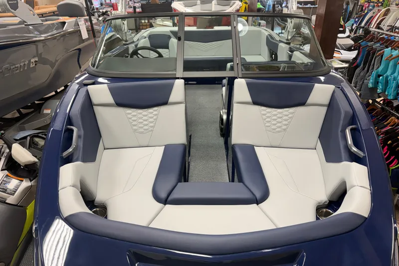 Slide: The Image of 2026 MasterCraft NXT20 boat interior with blue and white seating in showroom. - 15