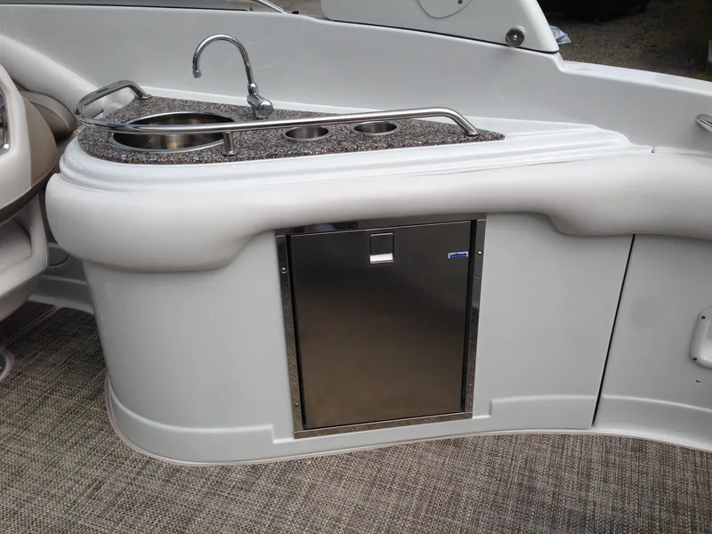 Slide: The Image of Crownline 285 SS 2016 boat kitchenette with sink and fridge. - 13