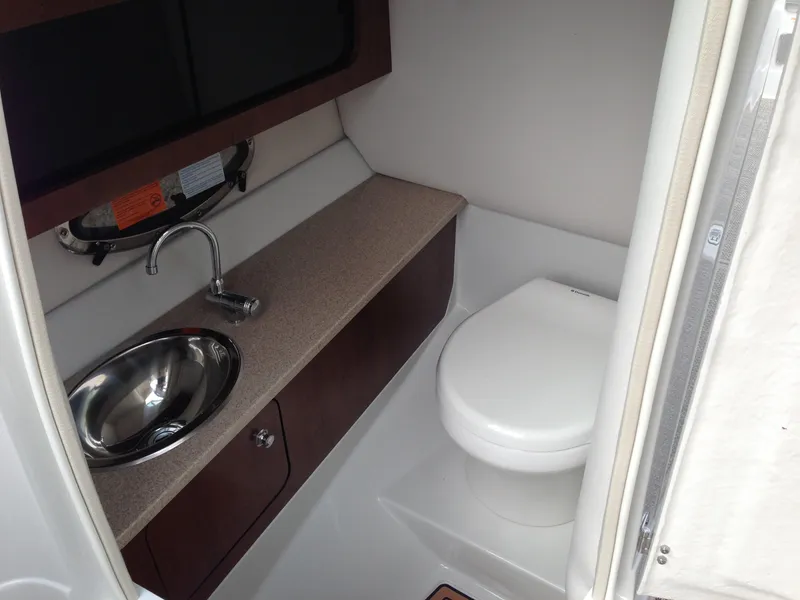 Slide: The Image of Interior of 2016 Crownline 285 SS with sink and toilet. - 19