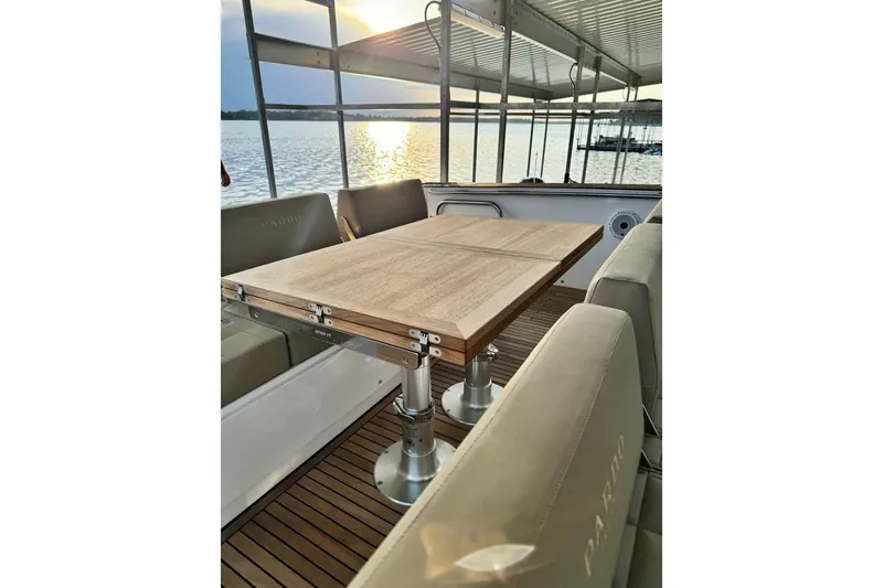 Slide: The Image of Luxurious 2021 Pardo Yachts P43 interior with elegant wooden table and seating, overlooking serene waters. - 13
