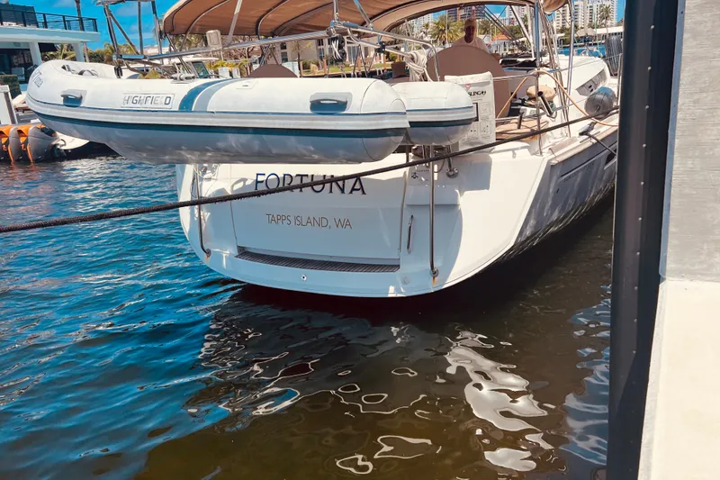 Slide: The Image of 2016 Jeanneau Sun Odyssey 519 yacht docked, featuring a dinghy and elegant design. - 11