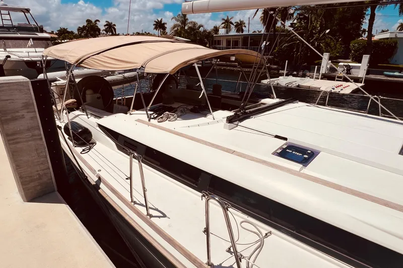 Slide: The Image of 2016 Jeanneau Sun Odyssey 519 yacht docked, featuring sleek design and beige canopy. - 16