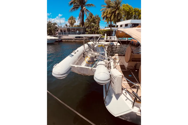 Slide: The Image of 2016 Jeanneau Sun Odyssey 519 yacht docked with inflatable dinghy, surrounded by palm trees. - 17