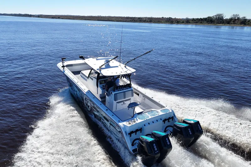 Slide: The Image of 2024 Front Runner 37 Catamaran cruising on open water with triple outboard engines. - 12