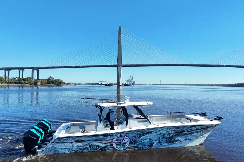 Slide: The Image of 2024 Front Runner 37 Catamaran cruising under a large bridge on a sunny day. - 24