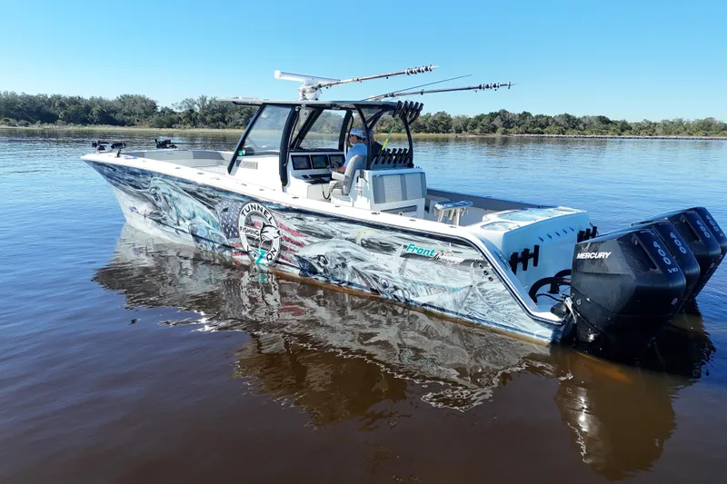 Slide: The Image of 2024 Front Runner 37 Catamaran with vibrant graphics and Mercury engines on calm water. - 26