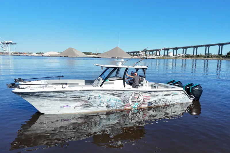 Slide: The Image of 2024 Front Runner 37 Catamaran on calm water, featuring vibrant graphics and dual outboard engines. - 58