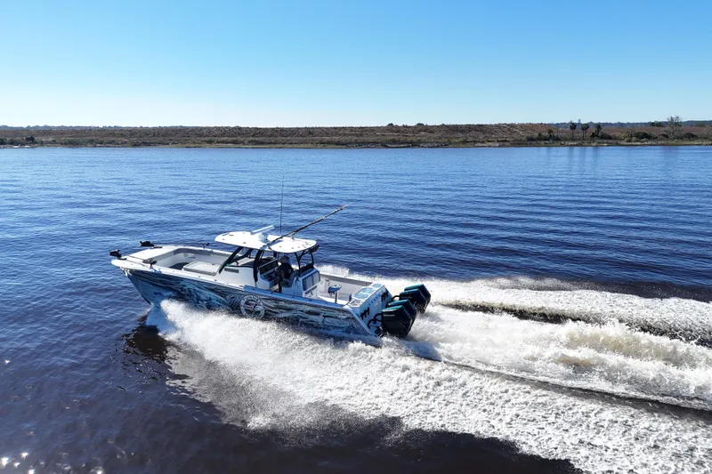 Slide: The Image of 2024 Front Runner 37 Catamaran cruising on a calm lake under clear blue skies. - 73