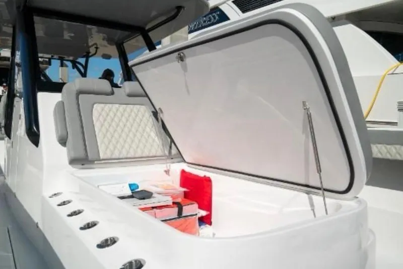 Slide: The Image of 2024 Front Runner 37 Catamaran with open storage compartment and cushioned seating. - 84