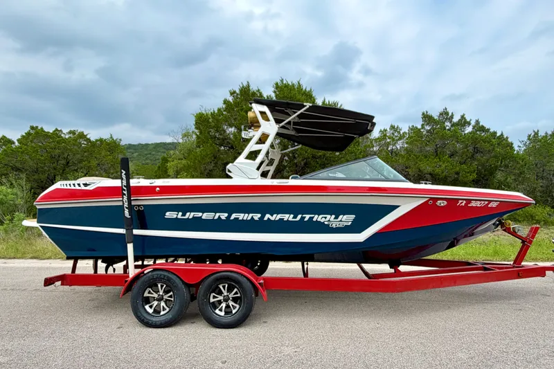 Slide: The Image of 2018 Nautique Super Air Nautique GS24 boat on red trailer, parked outdoors. - 10
