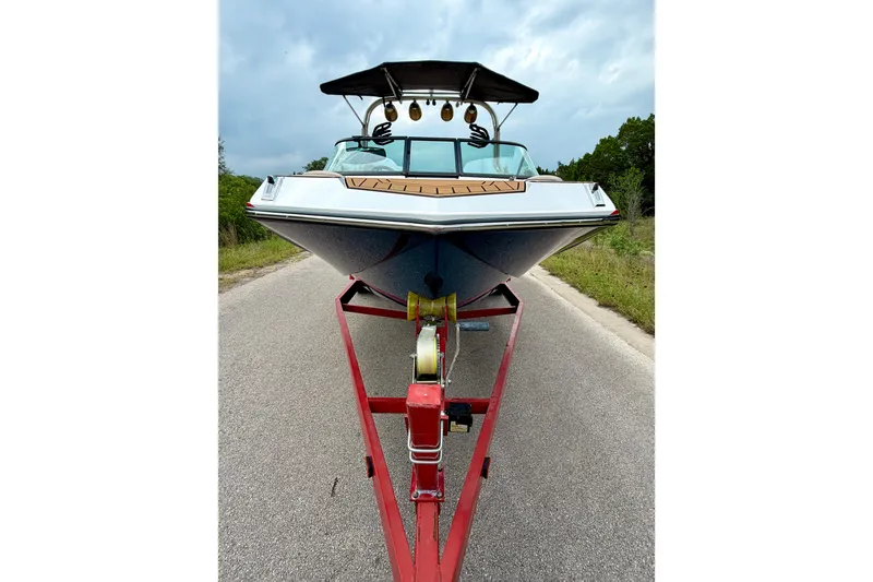 Slide: The Image of 2018 Nautique Super Air Nautique GS24 on trailer, parked on road under cloudy sky. - 12